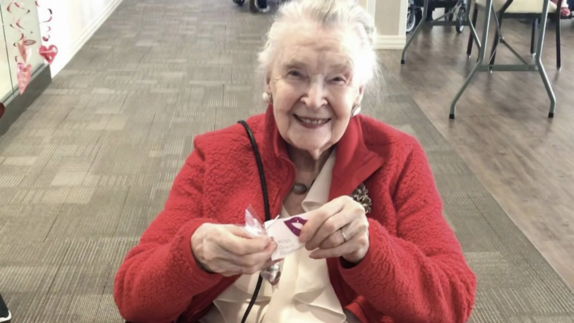 A senior citizen smiling while sitting on chair