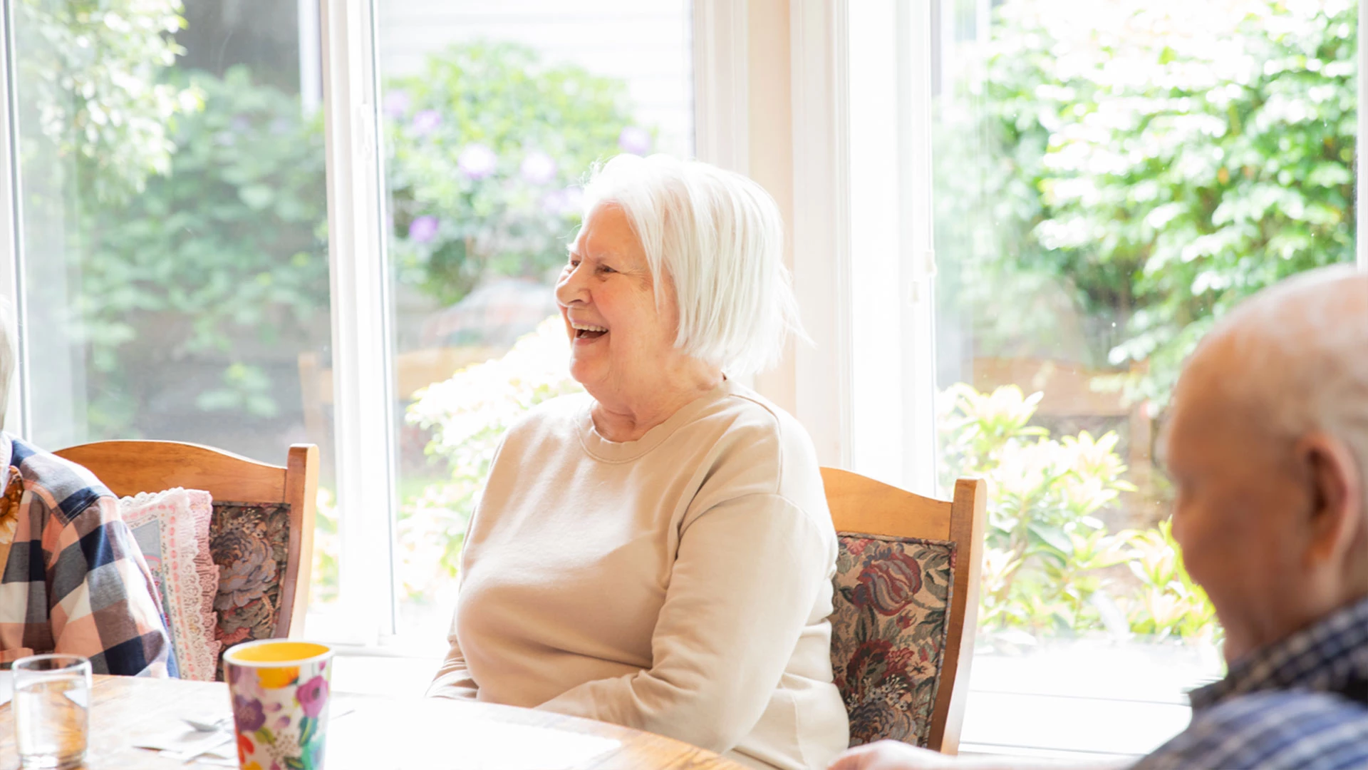 Senior smiling and seated at a table